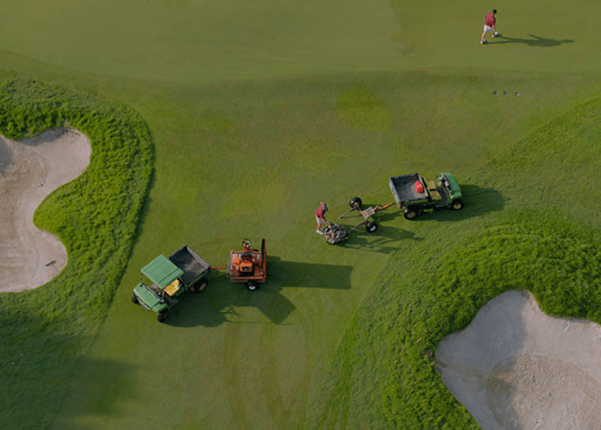 Aerial view of grounds crew and vehicles on a golf course