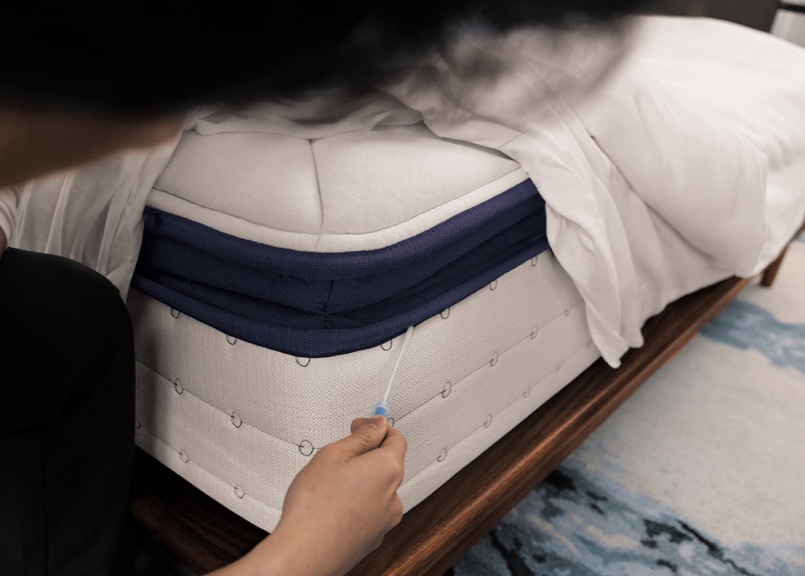 A person uses a bed bug detection product on a mattress.