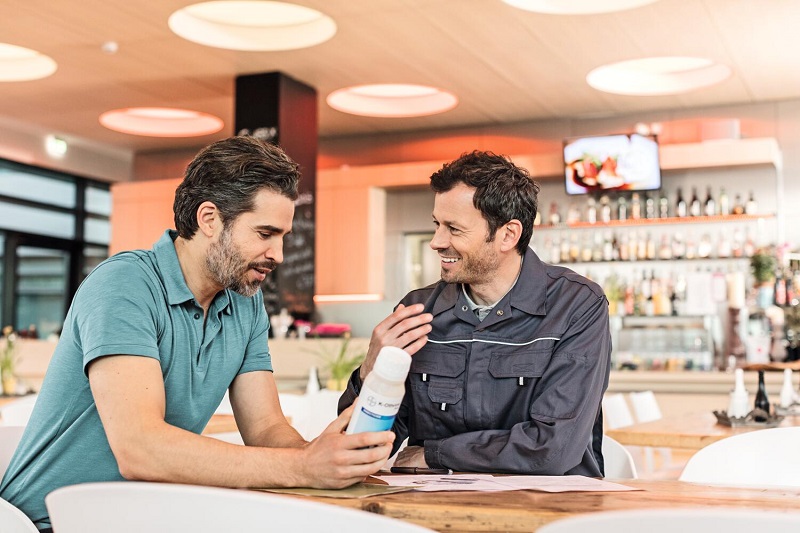 En skadedjurstekniker och hans kund för ett samtal på en restaurang