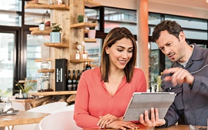 man and woman reviewing tablet