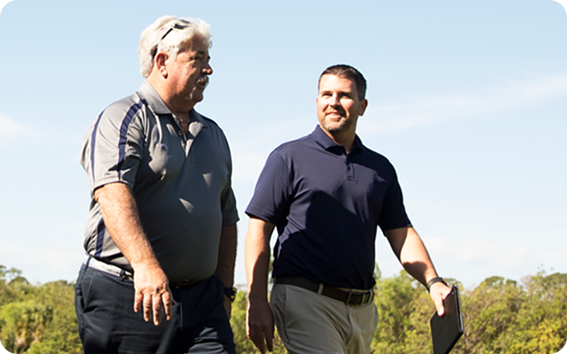 two men walking golf course
