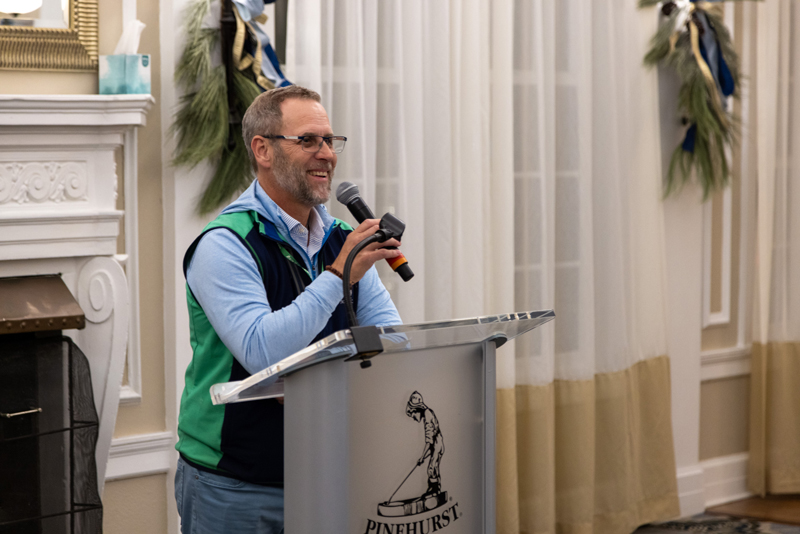 man standing a podium holding microphone