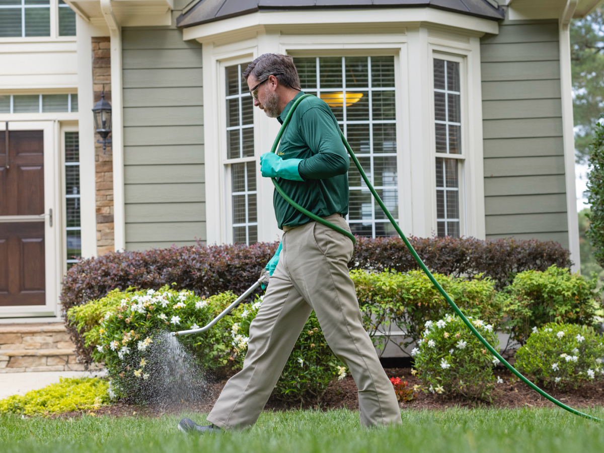 man wearing ppe spraying product