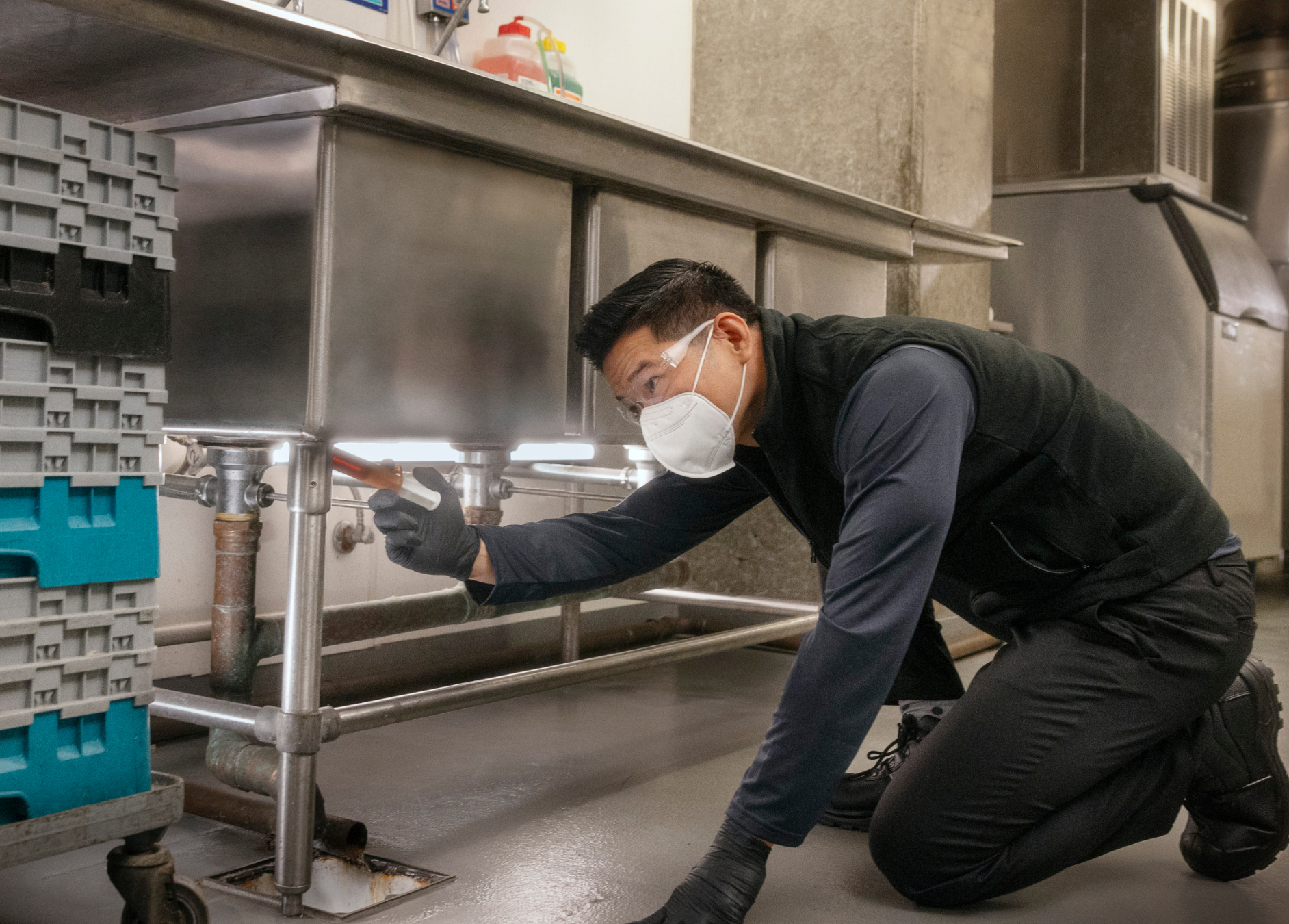 inspecting beneath commercial sink for pests