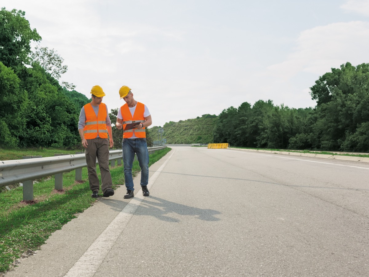 two people wearing safety gear on roadside
