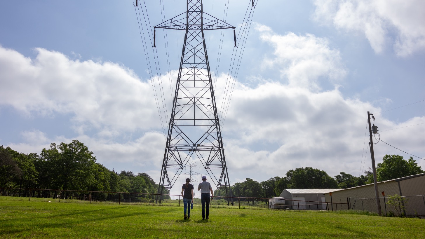 two people standing powerline in the distance