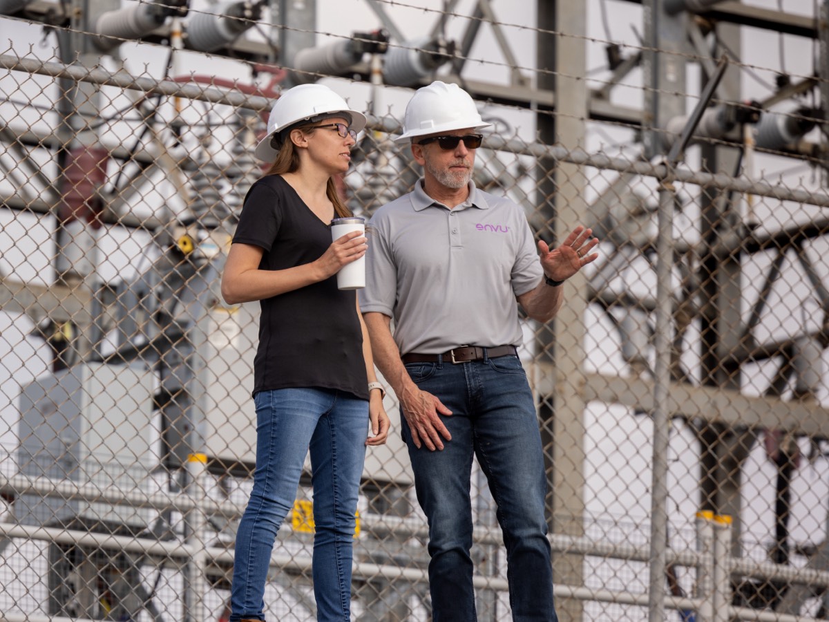 two people wearing hard hats talking
