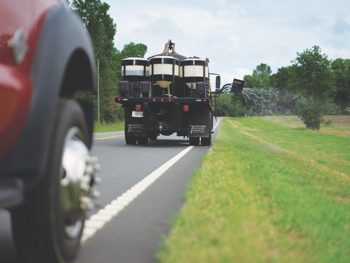 trucks driving down paved lined road