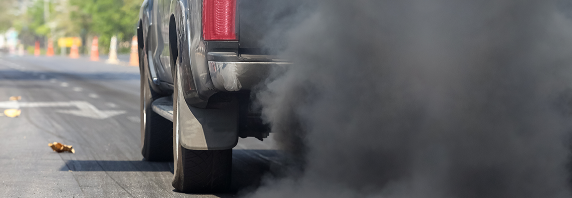 grey truck emissions along roadway